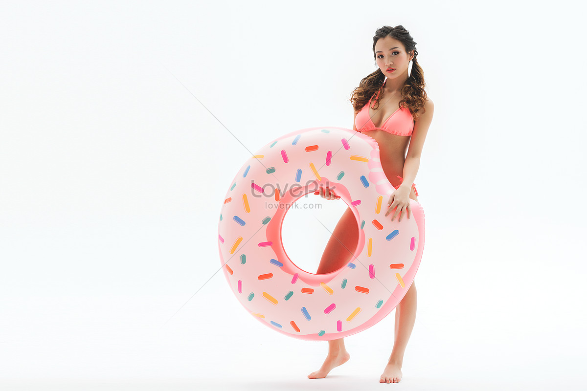 Linda Chica En Bikini Rosa Sosteniendo Donas Anillo De Natación Foto