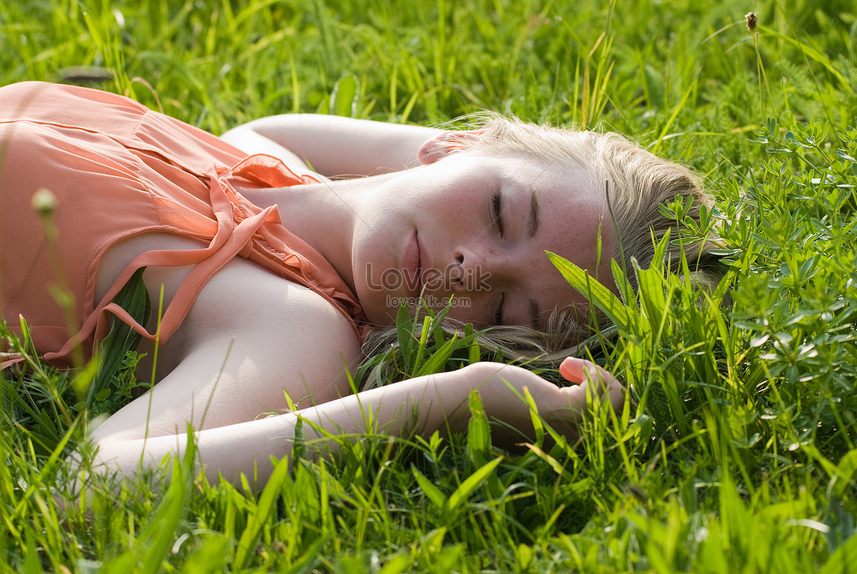 Голенькая девчонка валяется на траве и дрочит киску