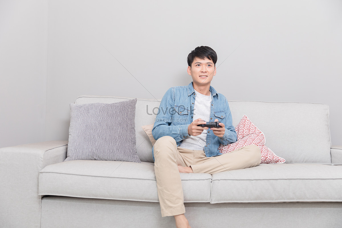 Bathtub breast Inappropriate A Man Sitting On A Sofa Playing Games Picture And HD Photos | Free Download  On Lovepik