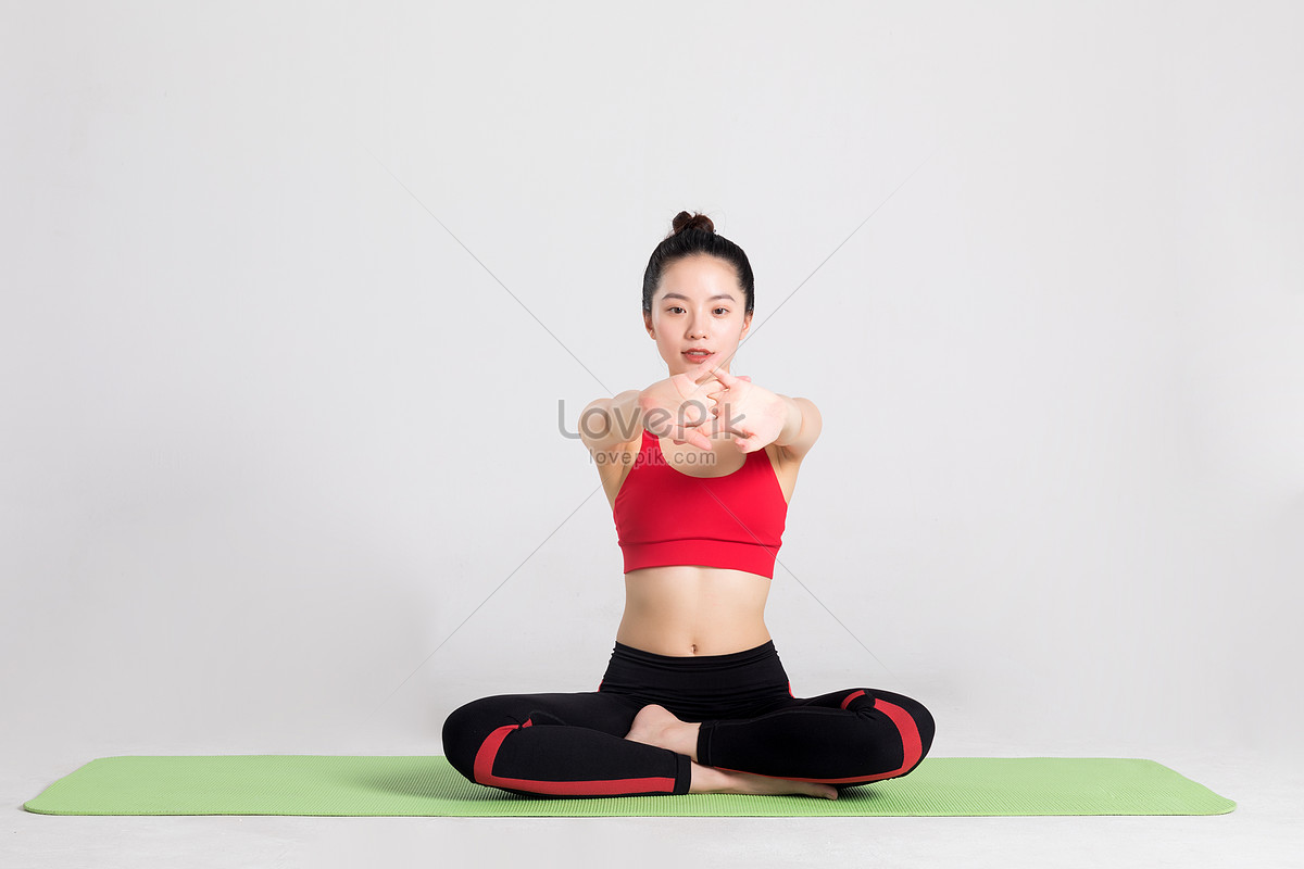 Женщина сидит на коврике для йоги делая упражнения на растяжку изображение_Фото номер 500669558_JPG Формат изображения_ru.lovepik.com