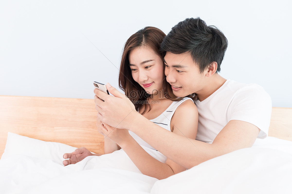 He loves to play. Lovers Play. Two people smiling on the Bed.