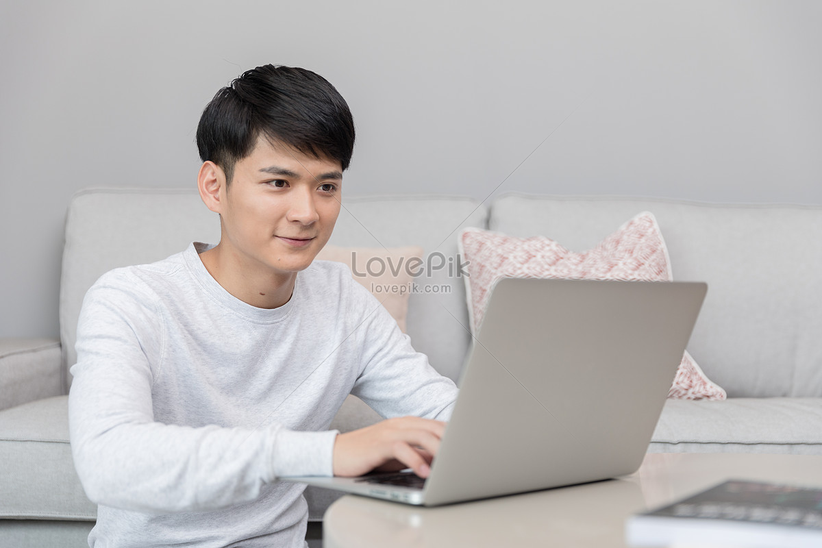 Молодой человек сидит на диване и играет на компьютере изображение_Фотономер 500715244_JPG Формат изображения_ru.lovepik.com