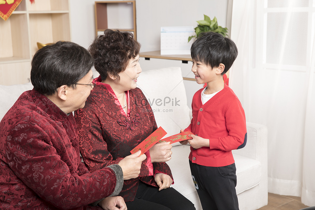 Бабушка внукам дает красные конверты. Дедушка дает деньги