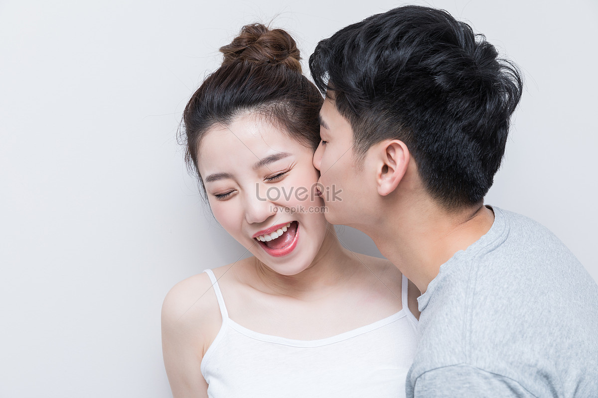 Европеец и азиатка целуются. Женские групповые фото поцелуй в щёчки.