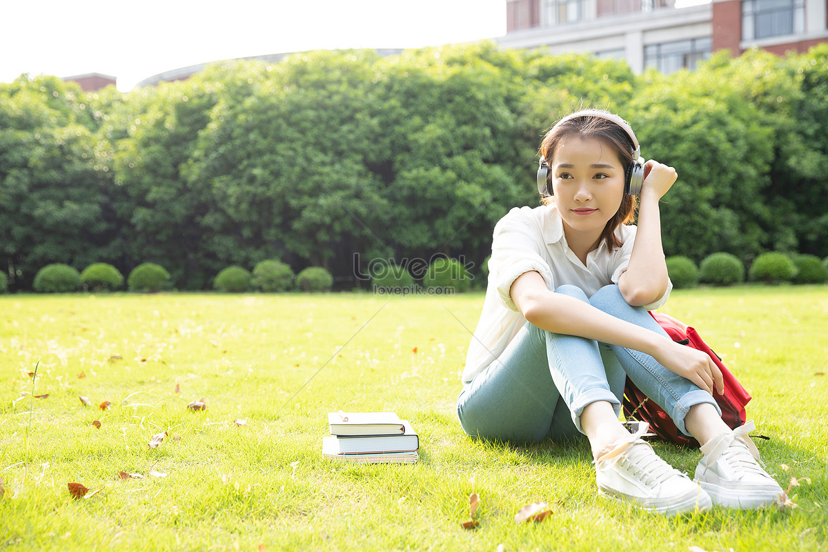 Совсем молодой девчонка. Девушка сидит на траве. Девушка в наушниках на траве. Девушка слушает музыку в парке. Красивая девушка в наушниках на траве.