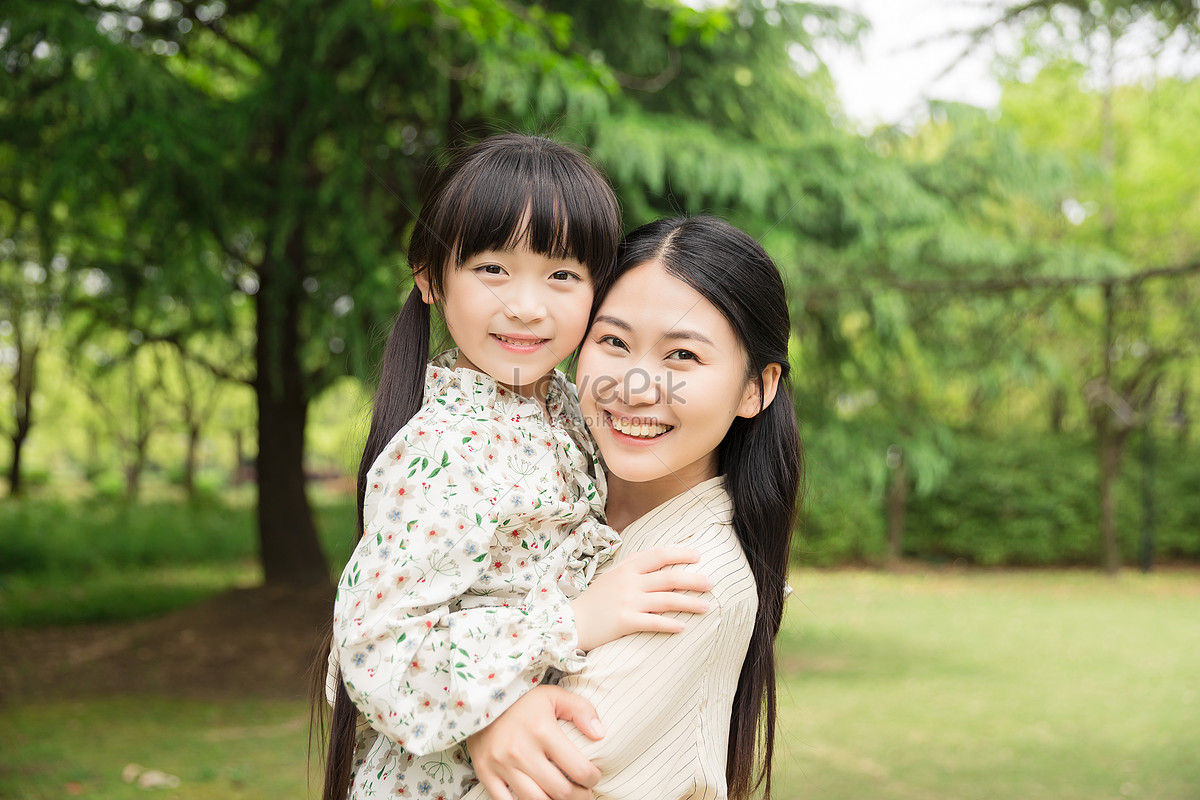 Японское жена и дочь. Мать и дочь Восточной внешности в саду.
