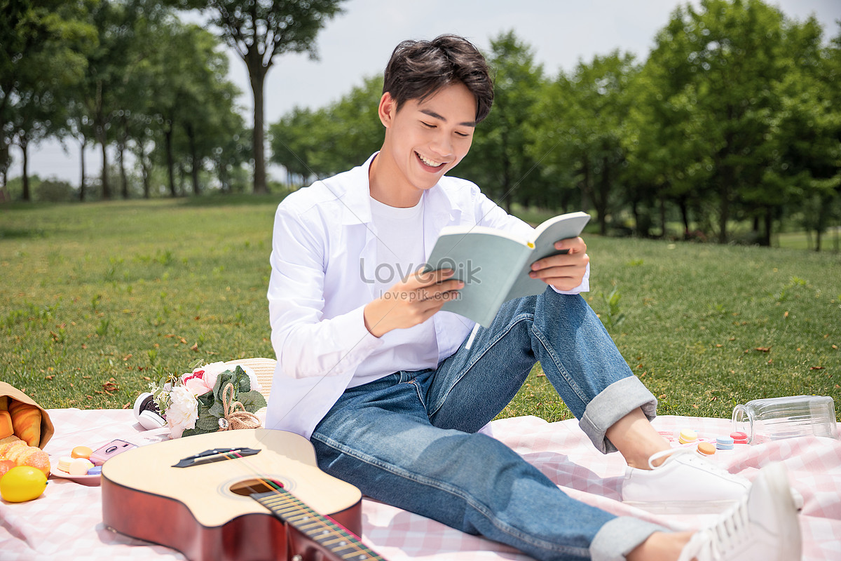 Мужчина младше читать. Парень читает книгу. Мужчина читает письмо. Молодой парень за чтением. На пикнике мужчина читает газету.