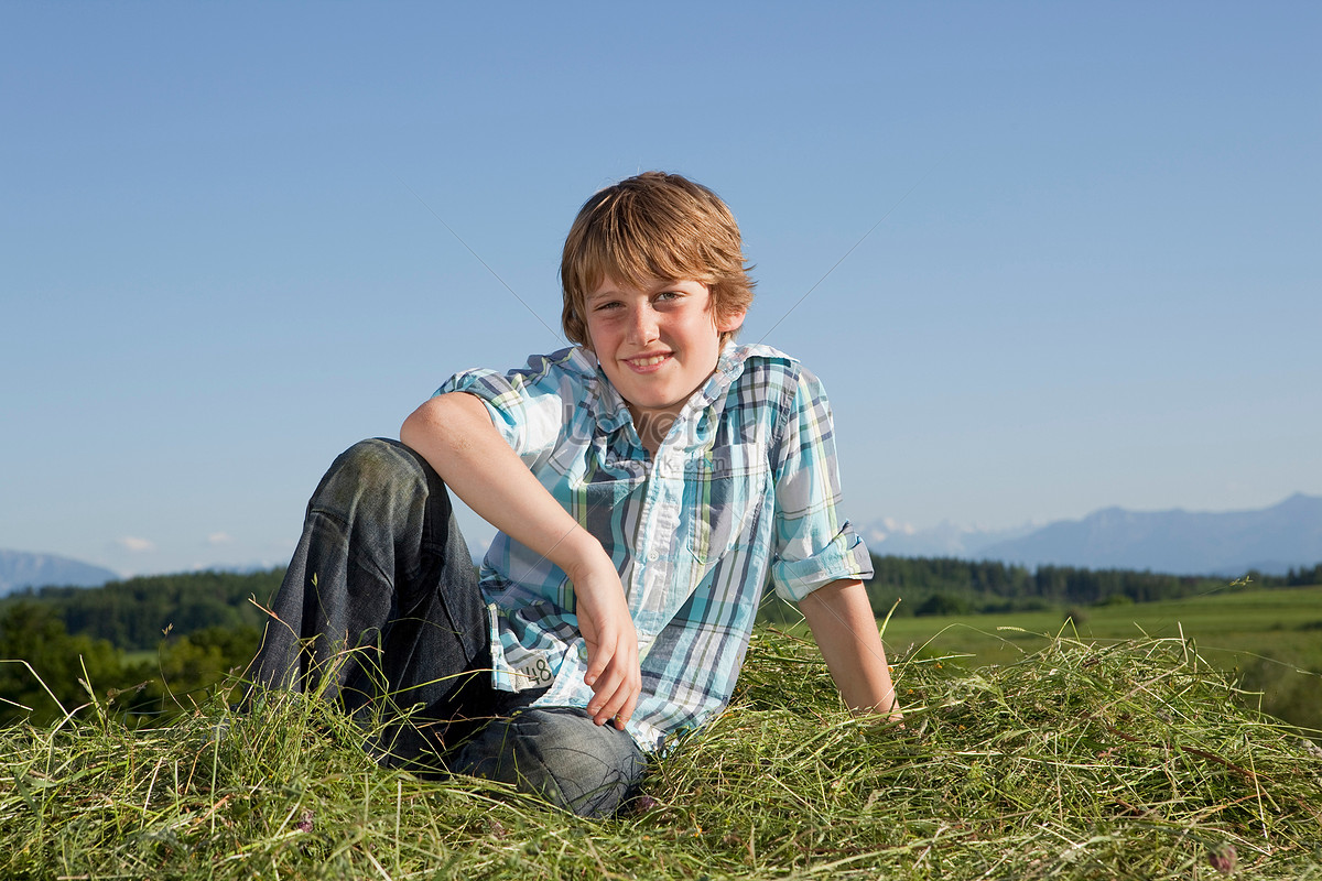 Мальчик сидит на траве
