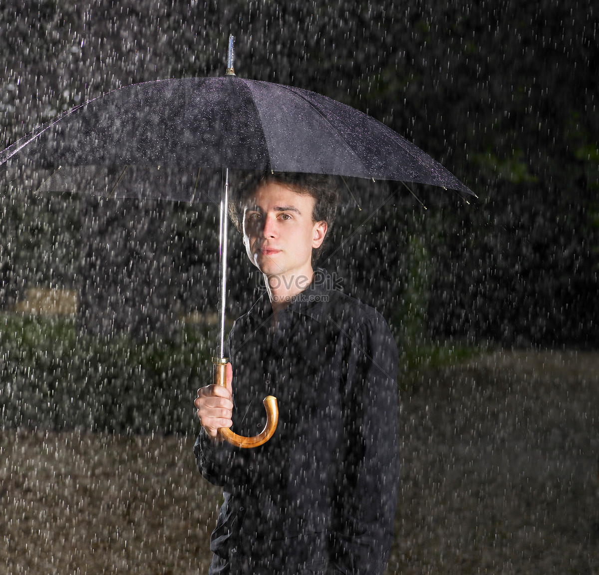 雨中带伞的男人在城市里图片-商业图片-正版原创图片下载购买-VEER图片库