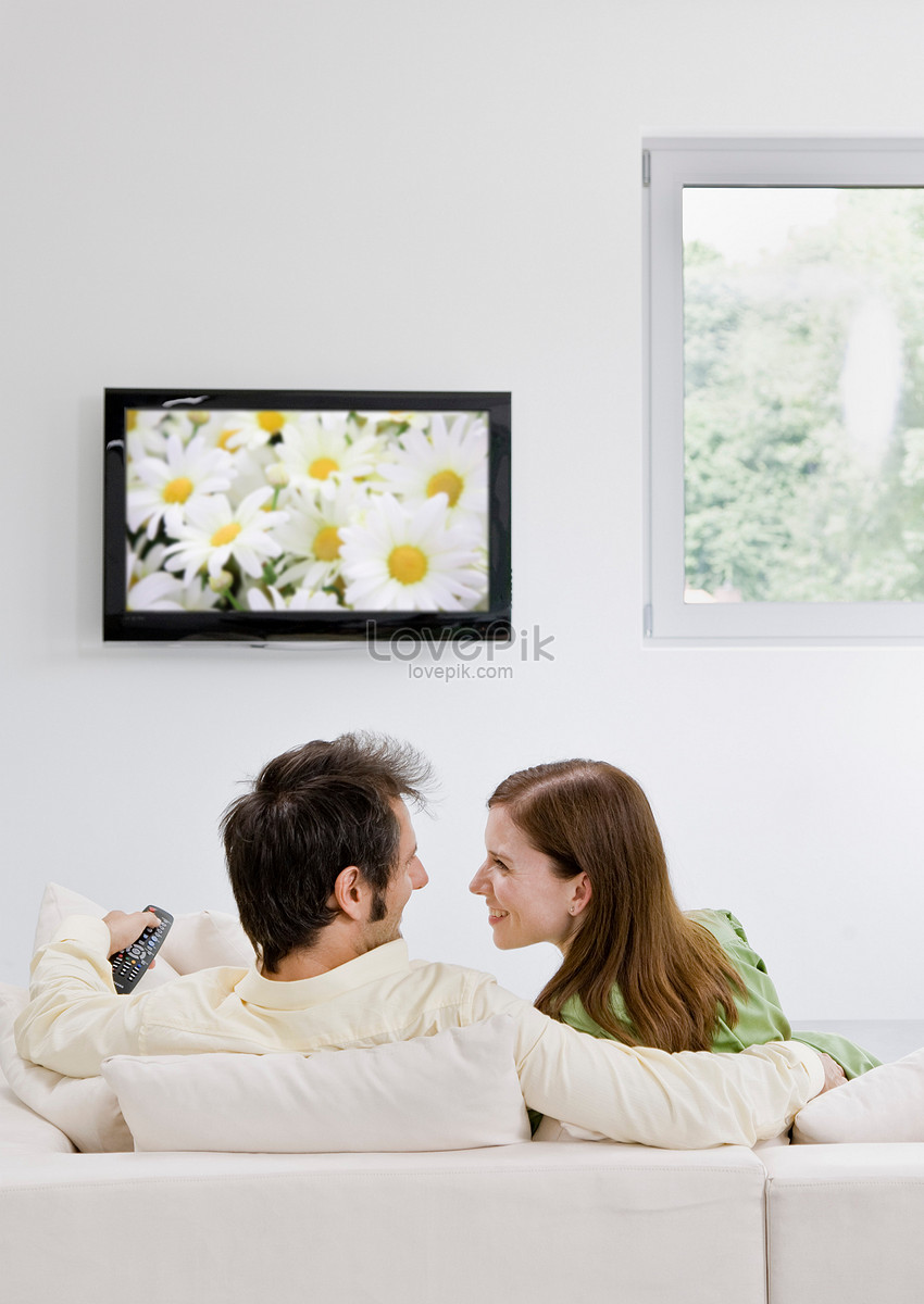 Тв вумен и коричневый камера. Мужчина и женщина у телевизора. Целует телевизор. Семья у телевизора спиной. Семья смотрит телевизор.