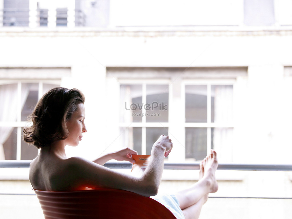Thấy hình ảnh người phụ nữ ngồi bên cửa sổ uống rượu, bạn nghĩ ngay đến một sự thư giãn và tận hưởng cuộc sống thật sự. Hãy thưởng thức hình ảnh này để cảm nhận sự thoải mái và sưởi ấm từ một ly rượu ngon nhé.