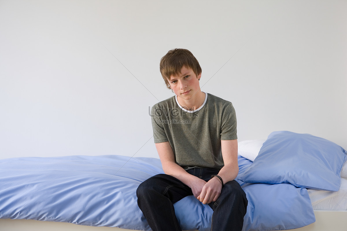 Boy Sitting On Bed Picture.