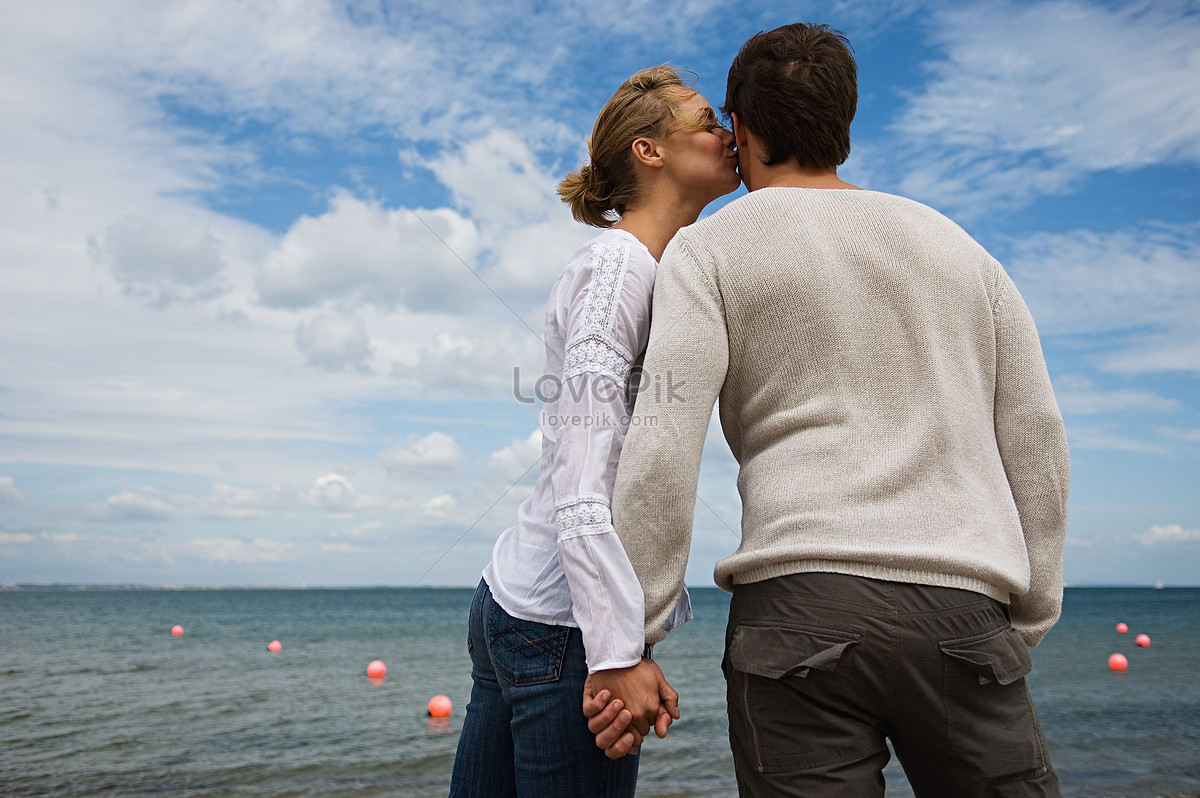 Муж целуется с любовником. Мужчина и женщина в море целуются. Пара целуется и третий лишний. Поцелуй в полный рост обычные люди.