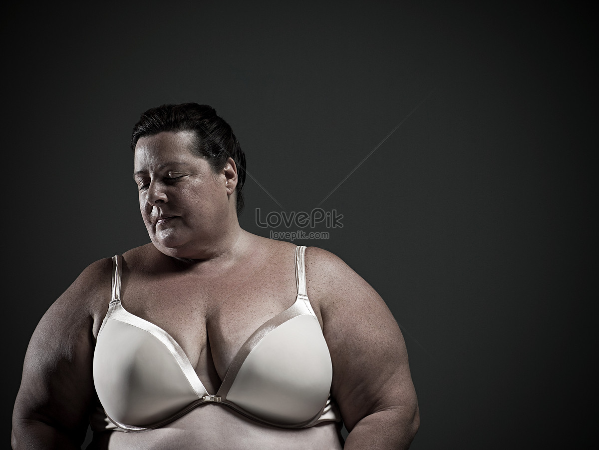 happy and overweight asian girl in jeans and bra jumping on grey, Stock  image