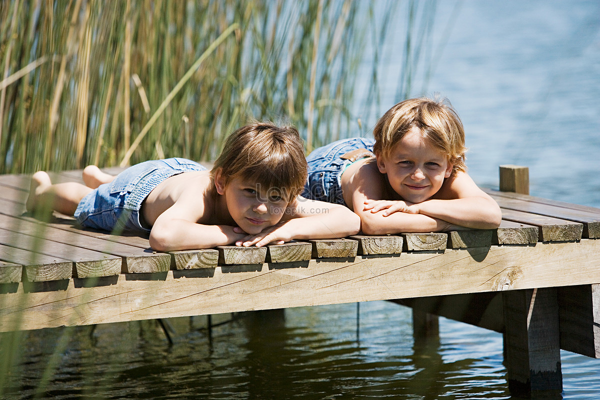 Девочка лежит на мальчике. Two boys at the Lake. Boyhood Companion.