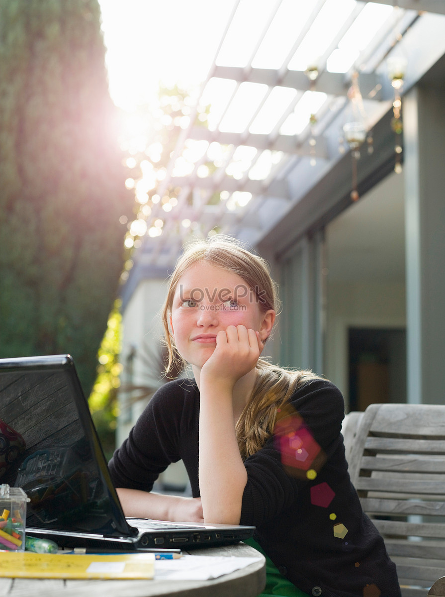 A woman, 20 years old, sits in front of a computer screen with a serious and stylish expression