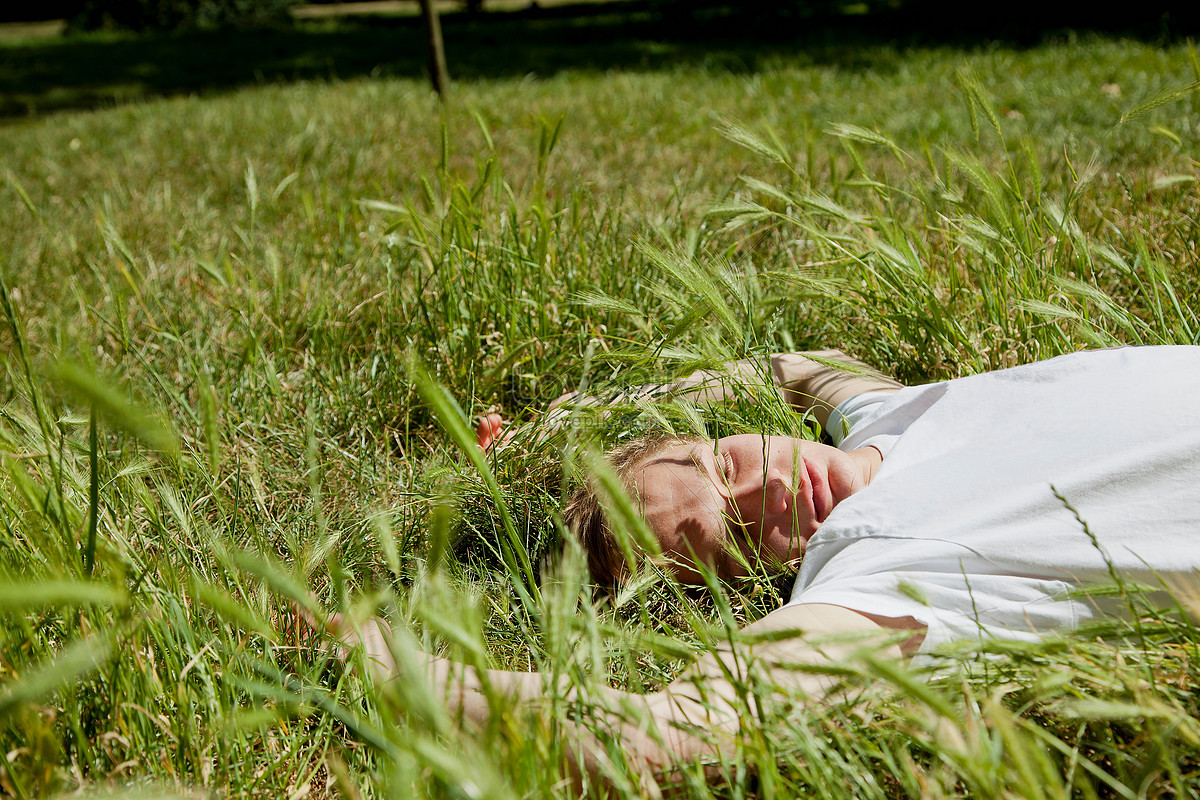 Подросток лежит на траве
