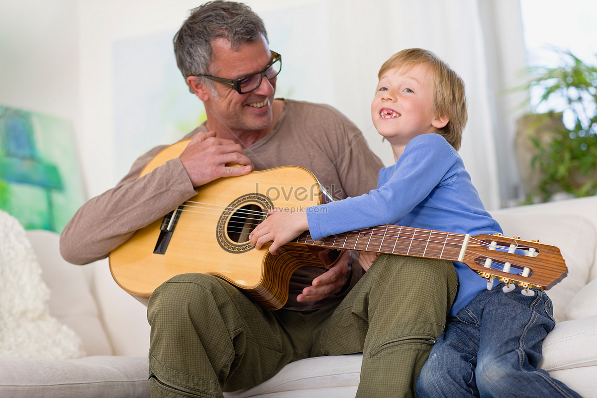 Гитара папа. Папа и сын играют на гитаре. Отец с гитарой. Папа учит сына игре на гитаре. Папа играет на гитаре