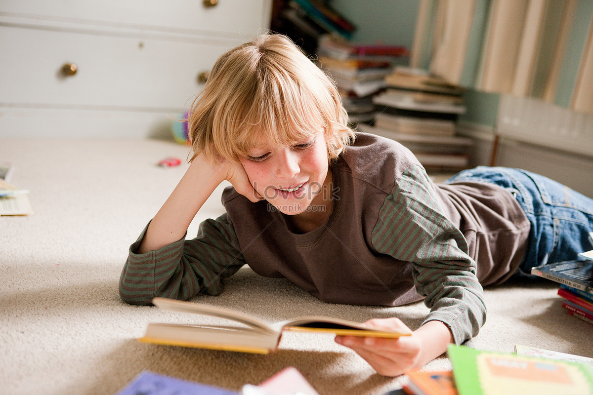 Little Boy Lying In Front Of Him Reading A Book In The Bedroom Picture ...