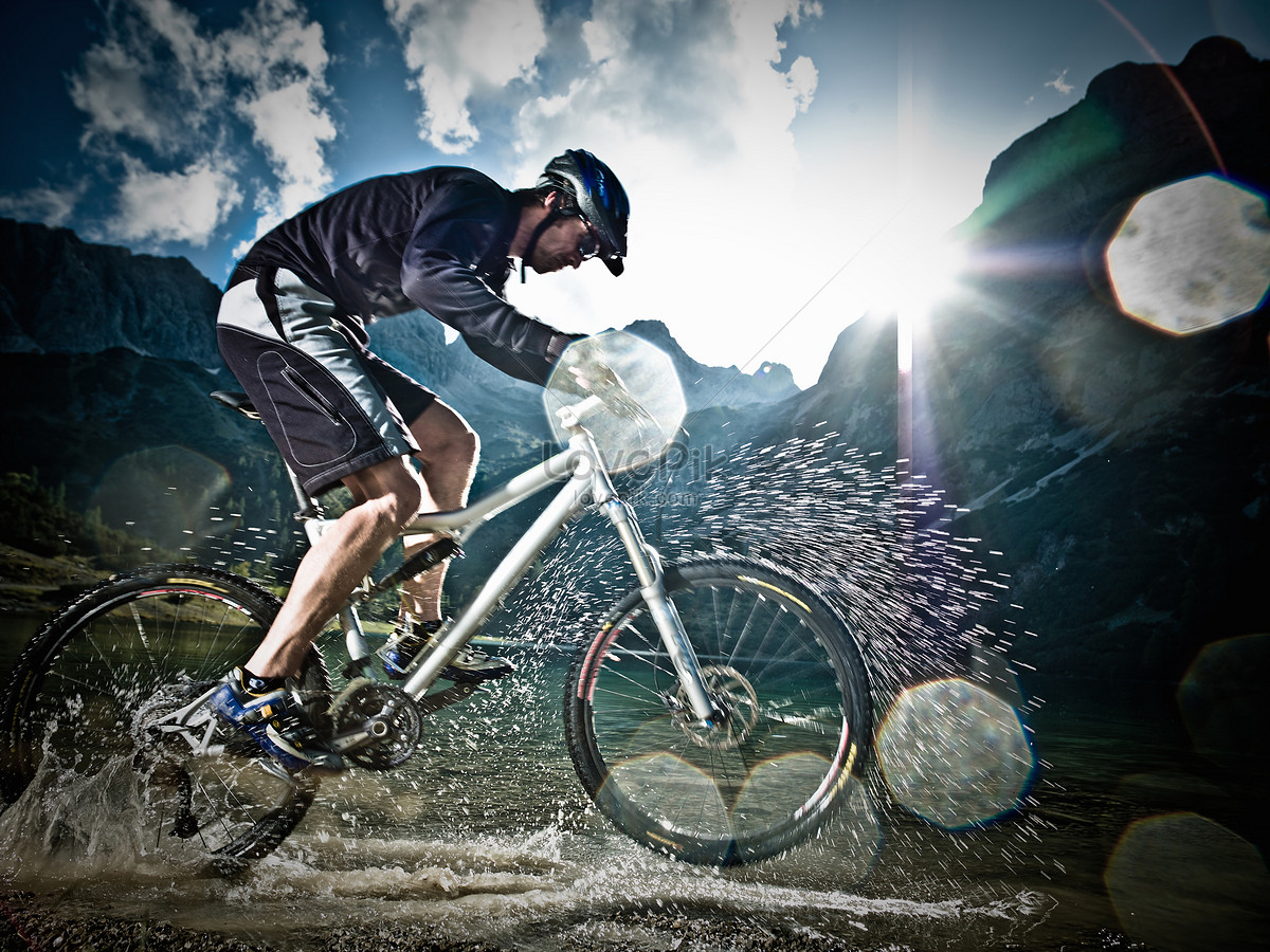 Hombre adulto joven en bicicleta de montaña levantando una rueda mientras  que monta en bicicleta en un sendero de montaña Fotografía de stock - Alamy
