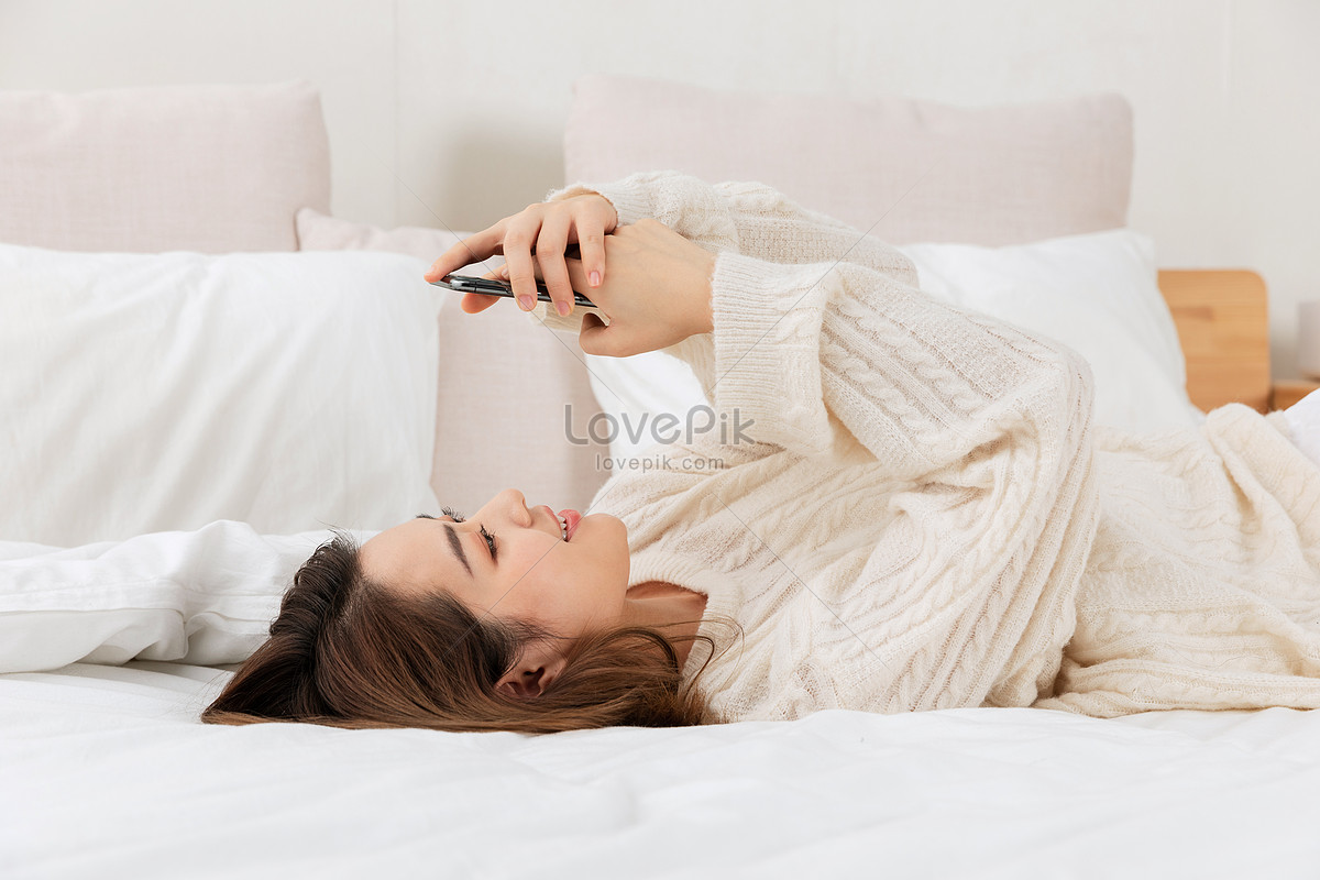 Фото Вид спереди молодой женщины в пижаме, оставшейся в постели и скрывающей лицо