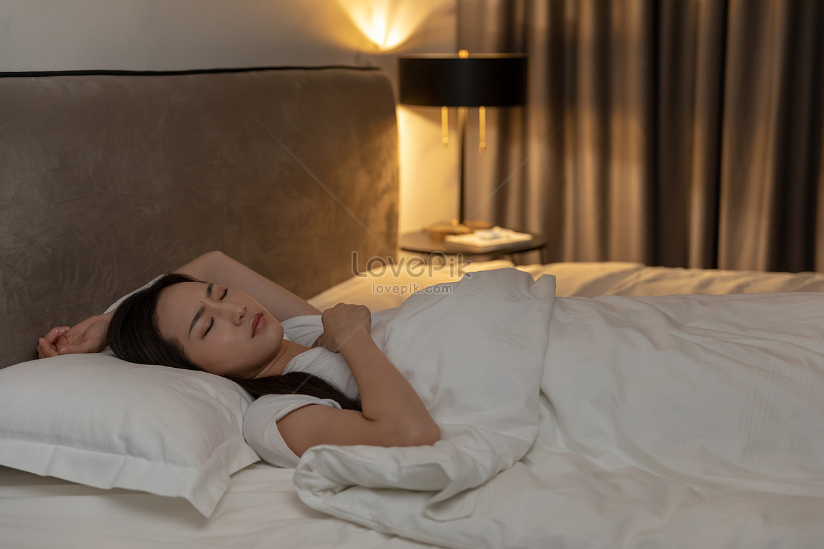 晚上睡在床上的年轻女人照片摄影图片_ID:388960366-Veer图库