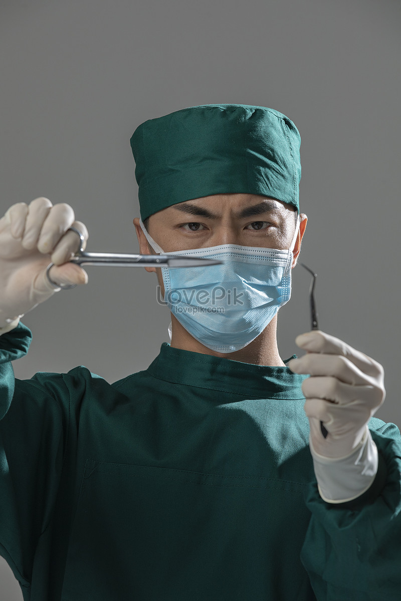 Male Doctor In Surgical Gown Holding Surgical Scissors Picture And HD ...