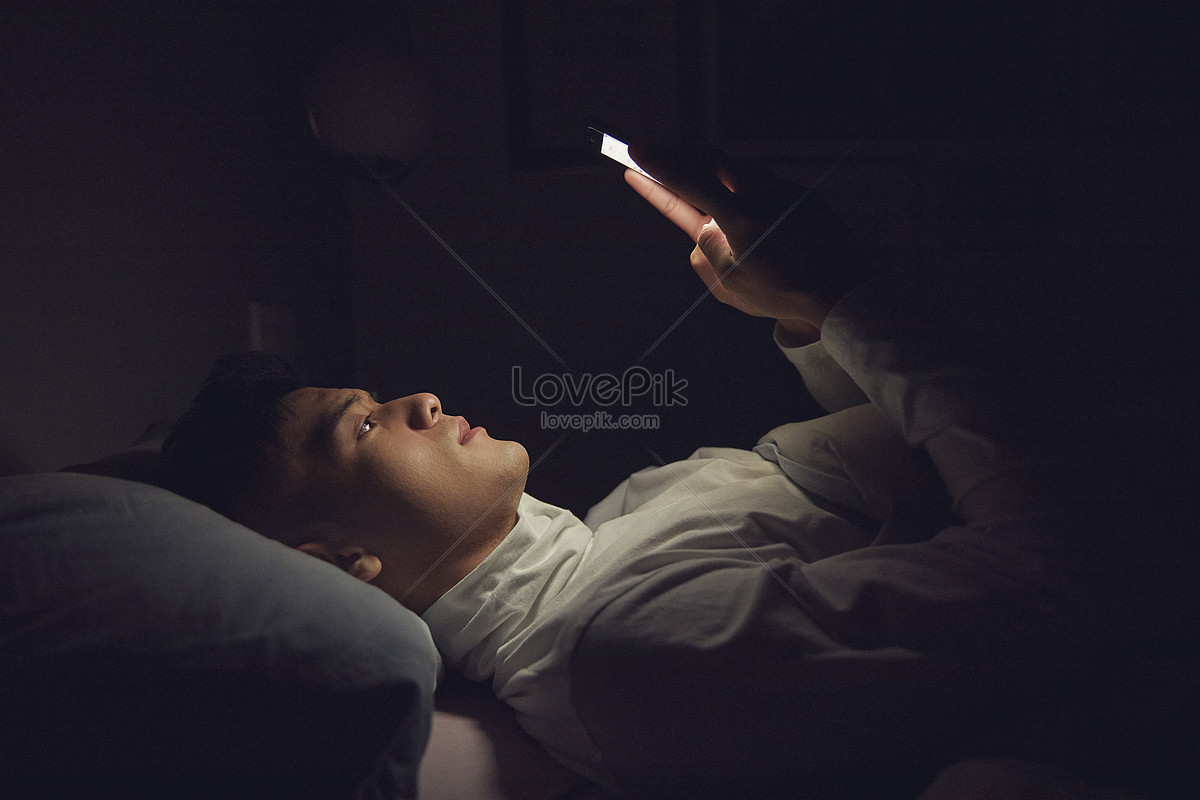 Men Lying On Pillows Playing Cell Phones Picture And HD Photos | Free ...