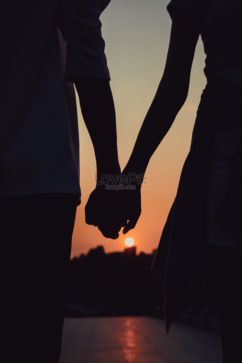Couple Holding Hands In The Sunset