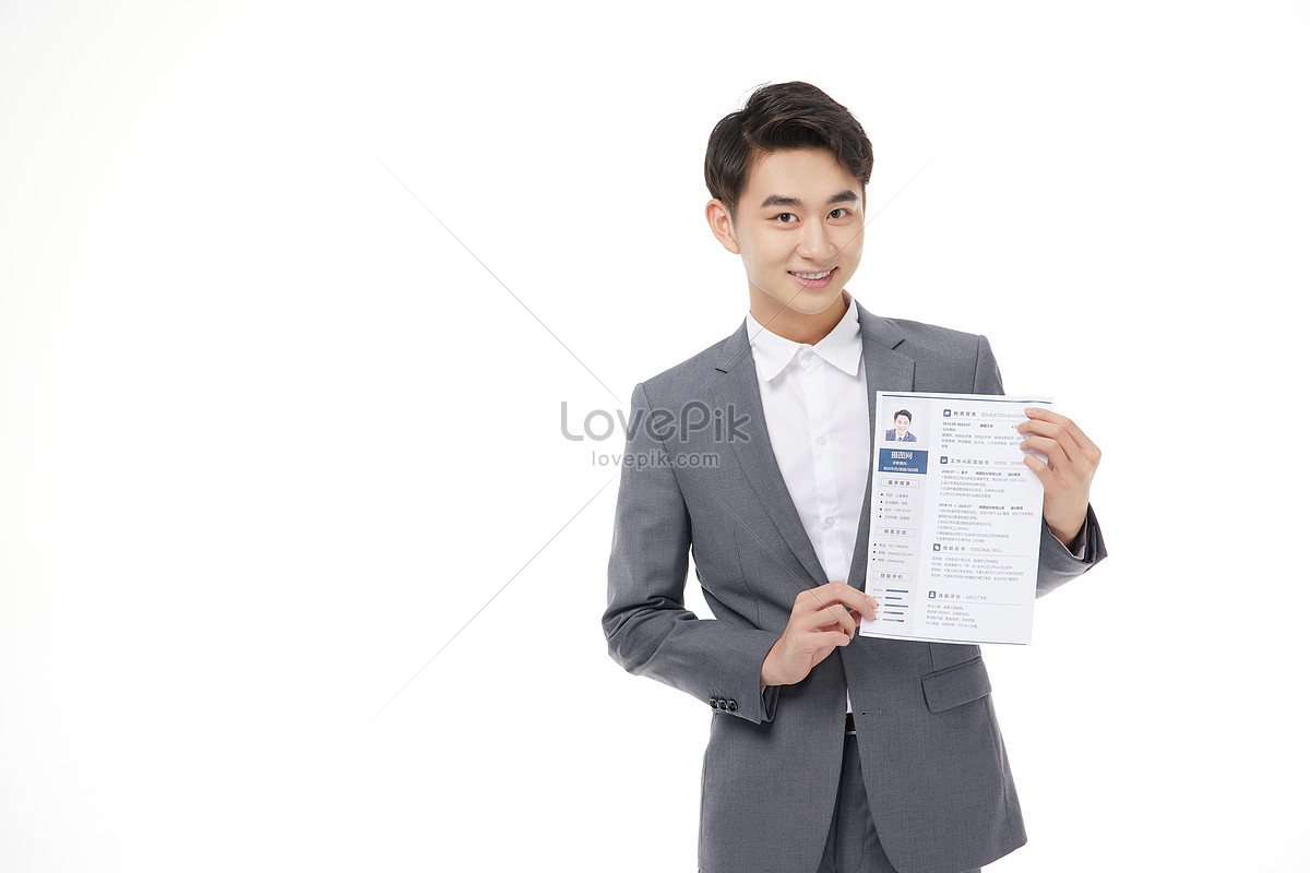 Confident Man Wearing Suit In Formal Office, Hand Holding Resume