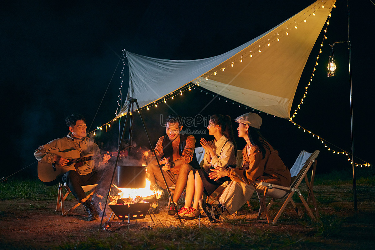 晚上拿着手电筒在篝火旁的女人。露营的季节照片摄影图片_ID:414047862-Veer图库
