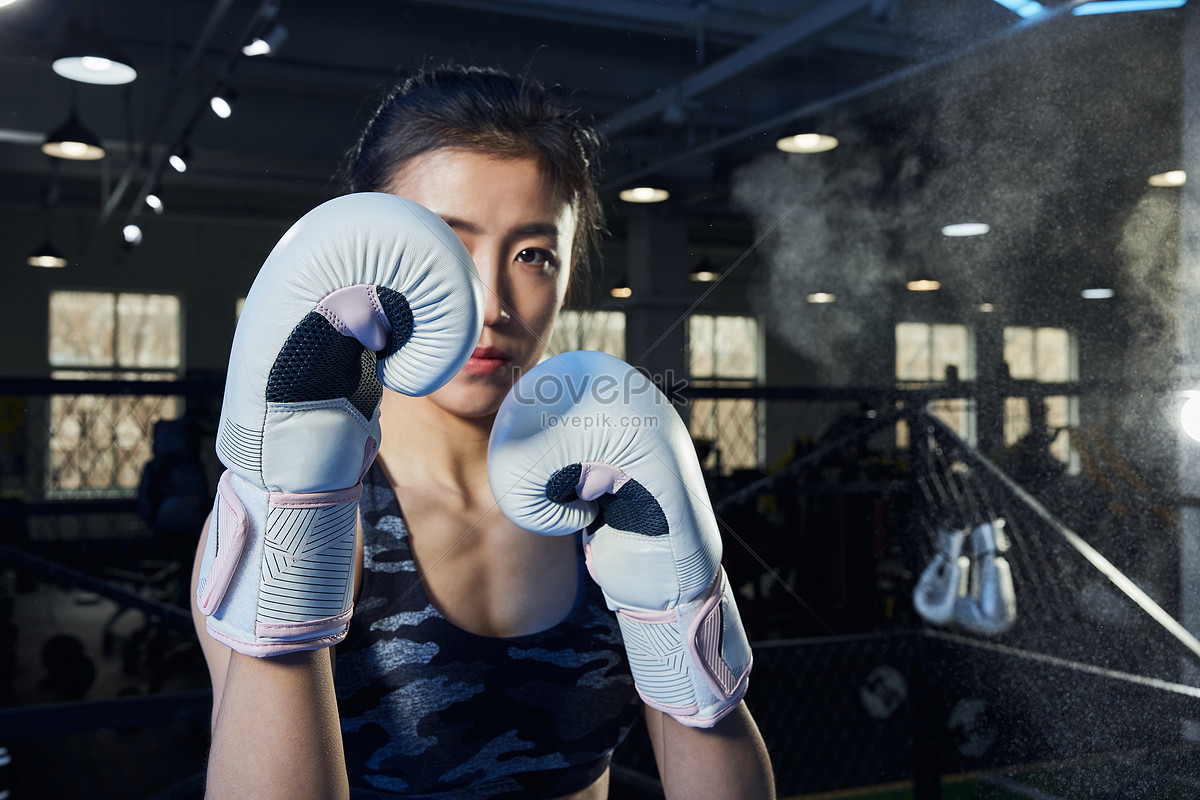 Female Boxer wearing gloves posing in boxing studio Stock Photo by  ©ufabizphoto 186026228