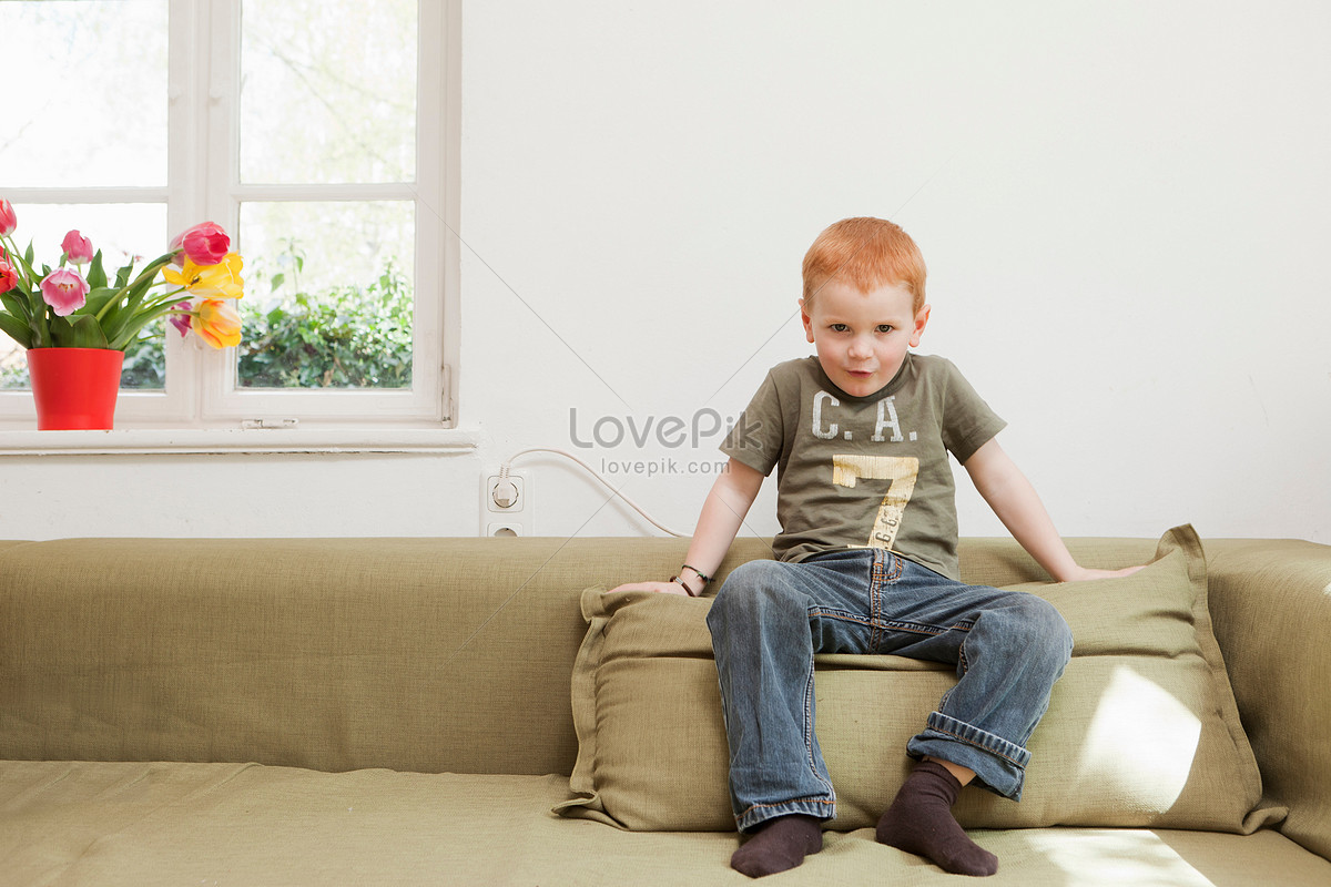 Мальчик сидит на диване
