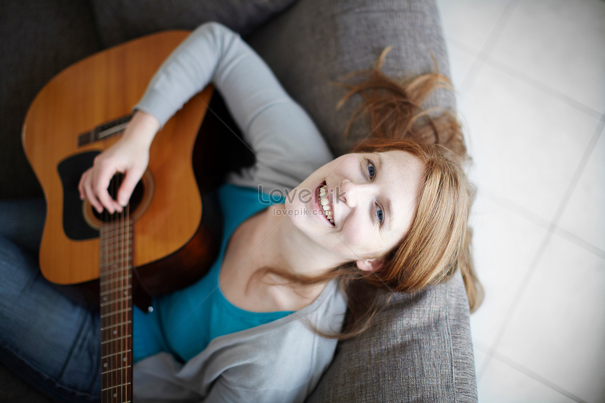 Клип девушка играет на гитаре. Диван гитара фото. Girl playing Guitar.