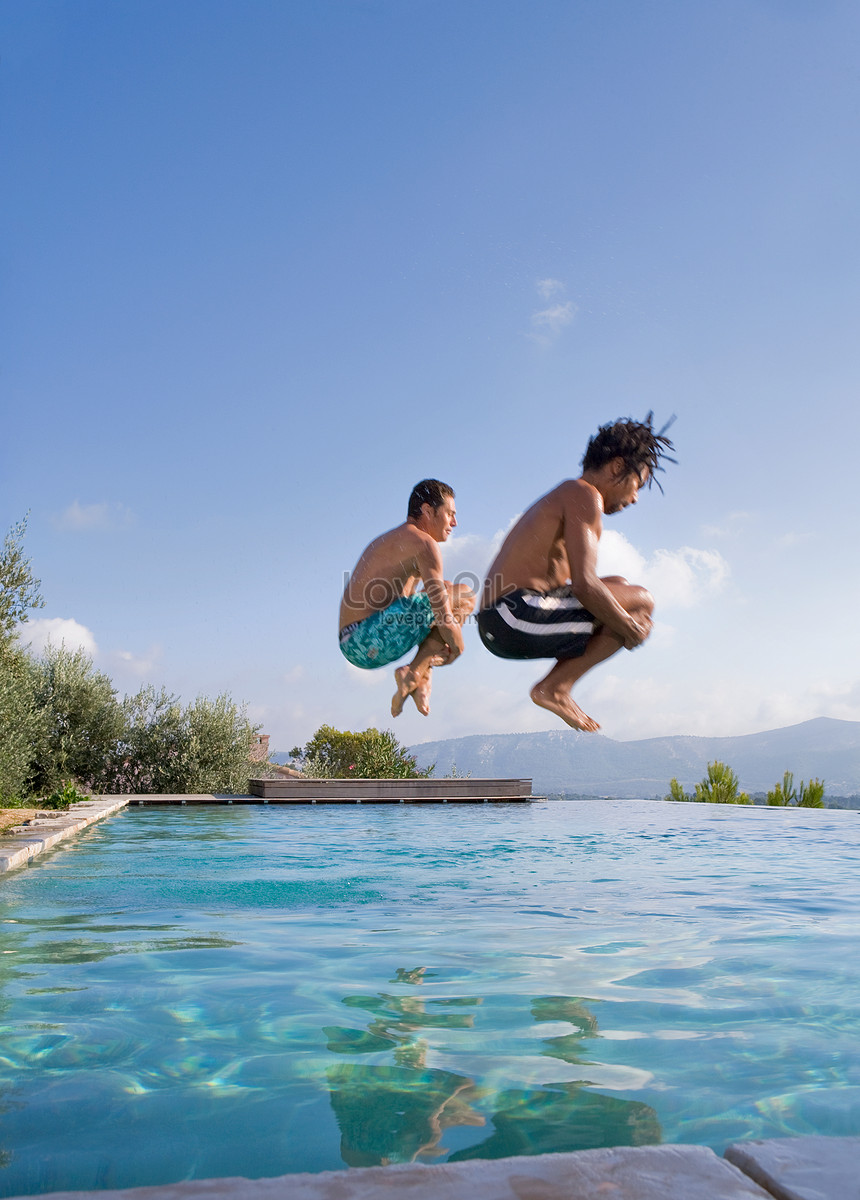 Young man jumping into a swimming pool photo image_picture