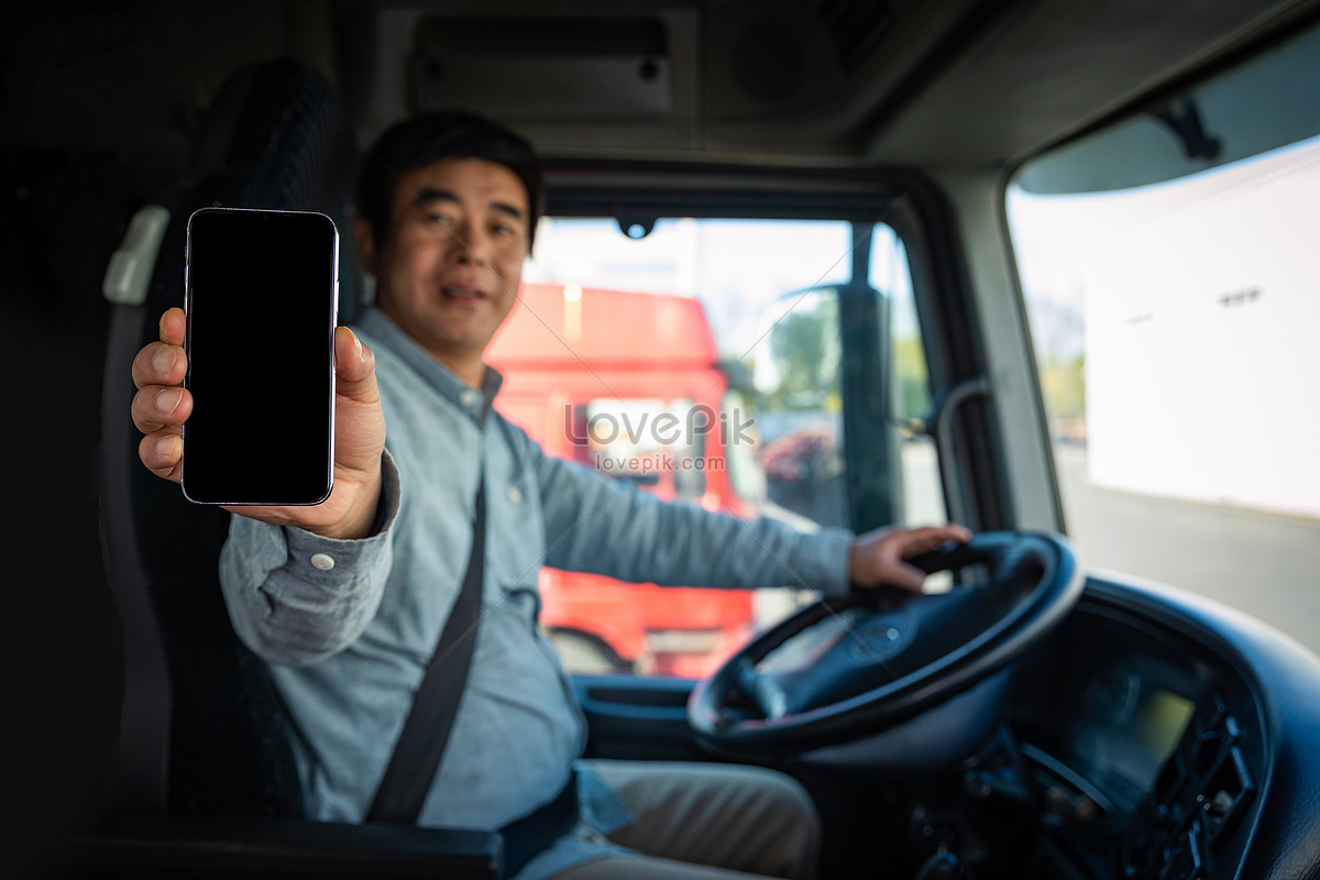 Truck driver holding mobile phone to show photo image_picture free