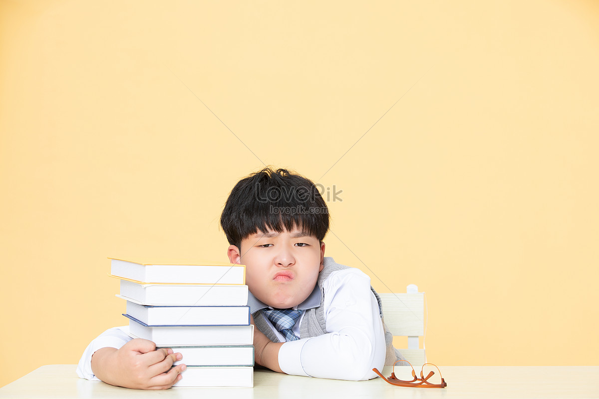 The little boy worried about studying is doing his homework Photo