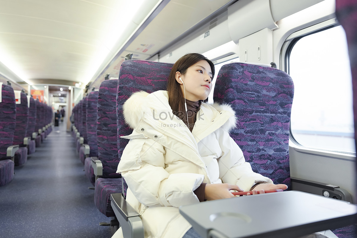 Women listening to music with headphones on the train during the journey stock pictures.  & images