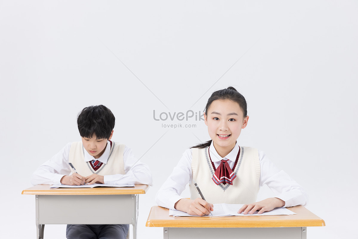 Middle school students in classroom studying and writing homework Photo