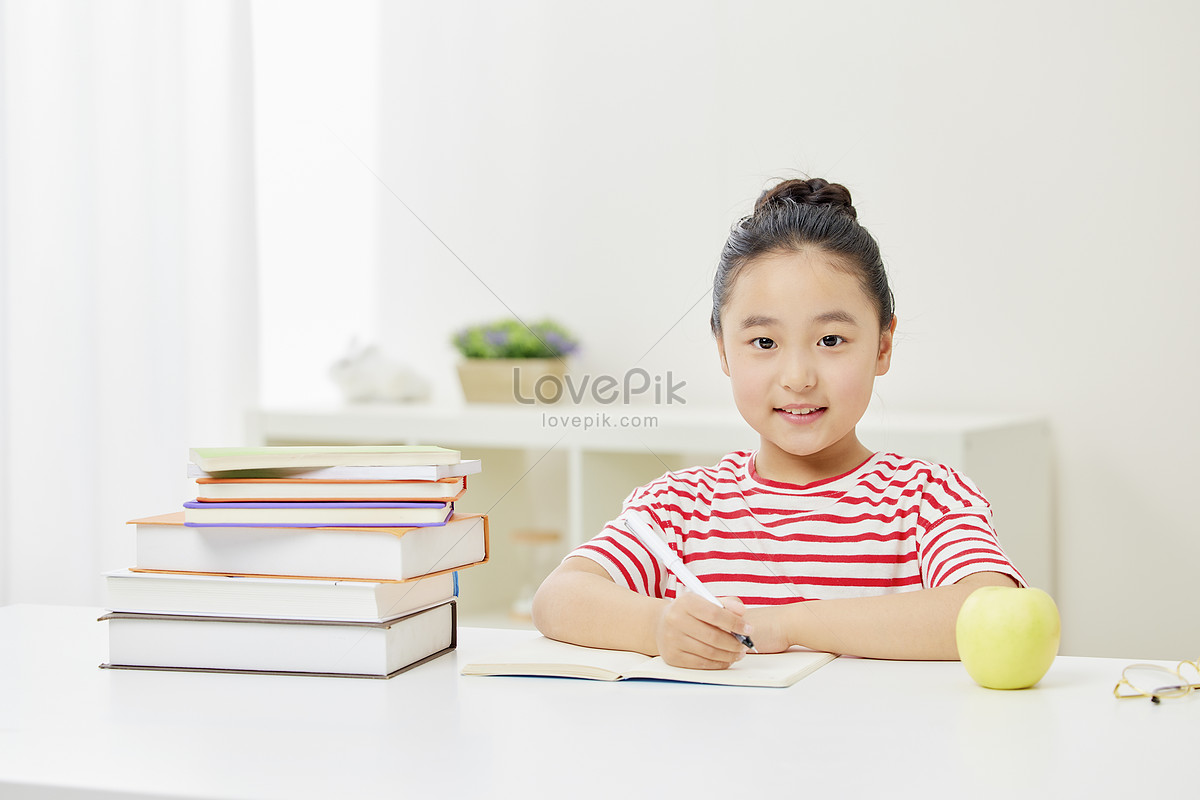 image of little girl doing homework seriously Photo