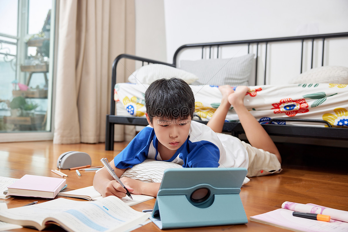little boy doing homework in summer living room Photo