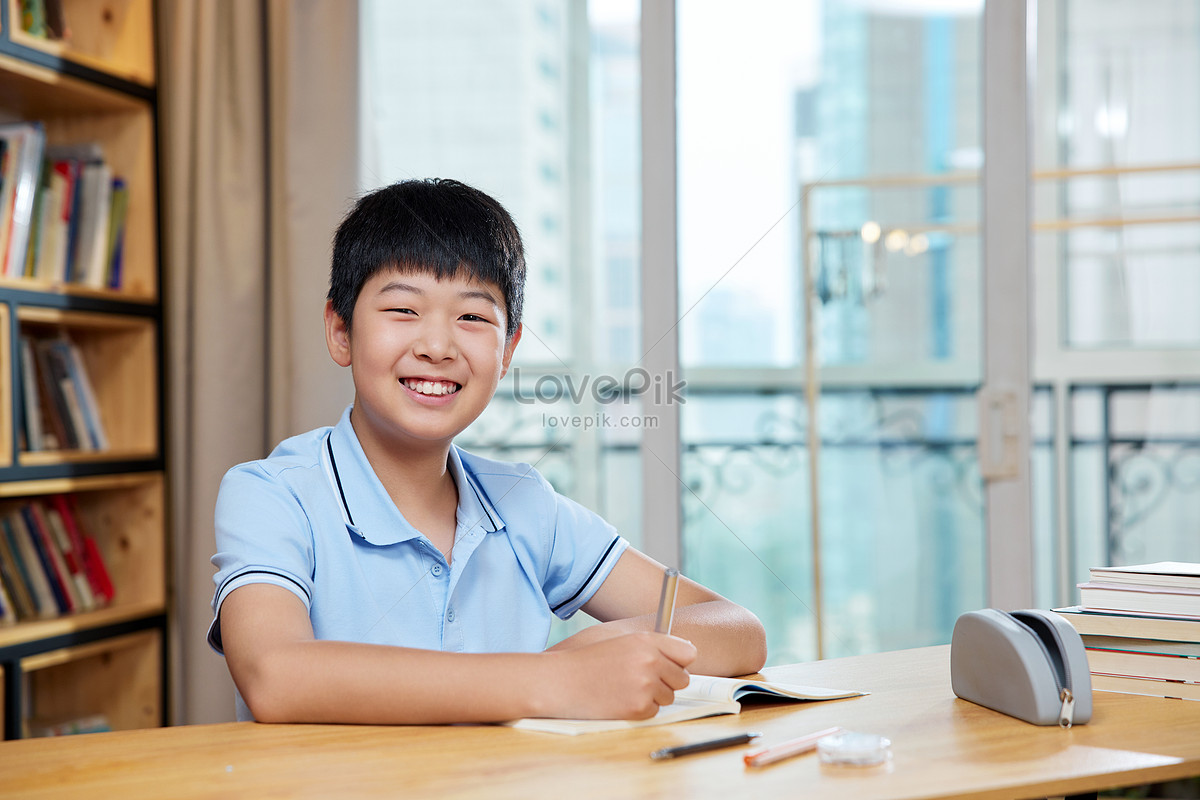 Smiling image of boy doing homework Photo