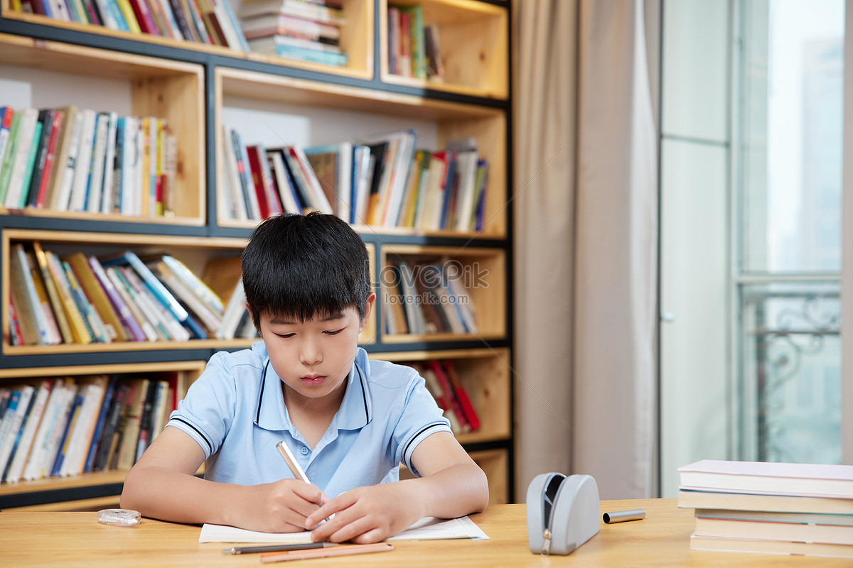 Boy quietly doing homework in study room Photo